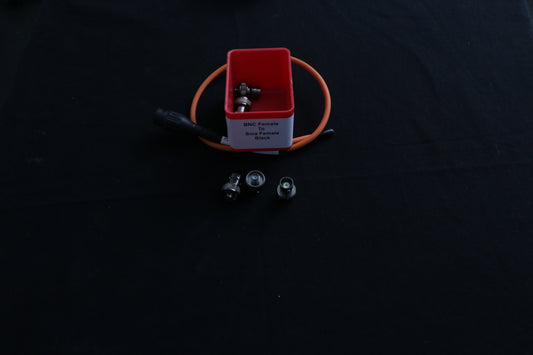 Small red box with SMA female to BNC female adapters