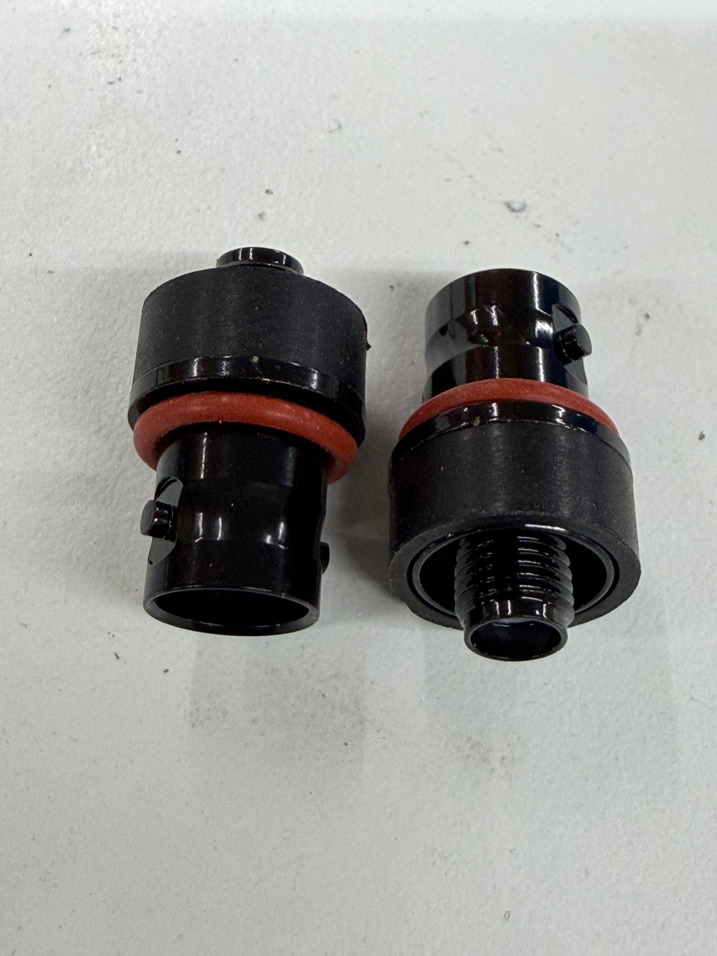Two black SMA female to BNC female narrow-wall adapters with orange O-rings